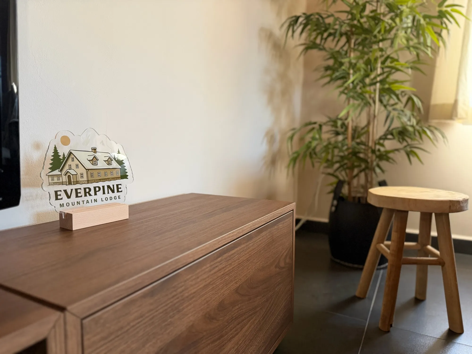 Everpine Mountain Lodge-bordje op een houten dressoir met kamerplant