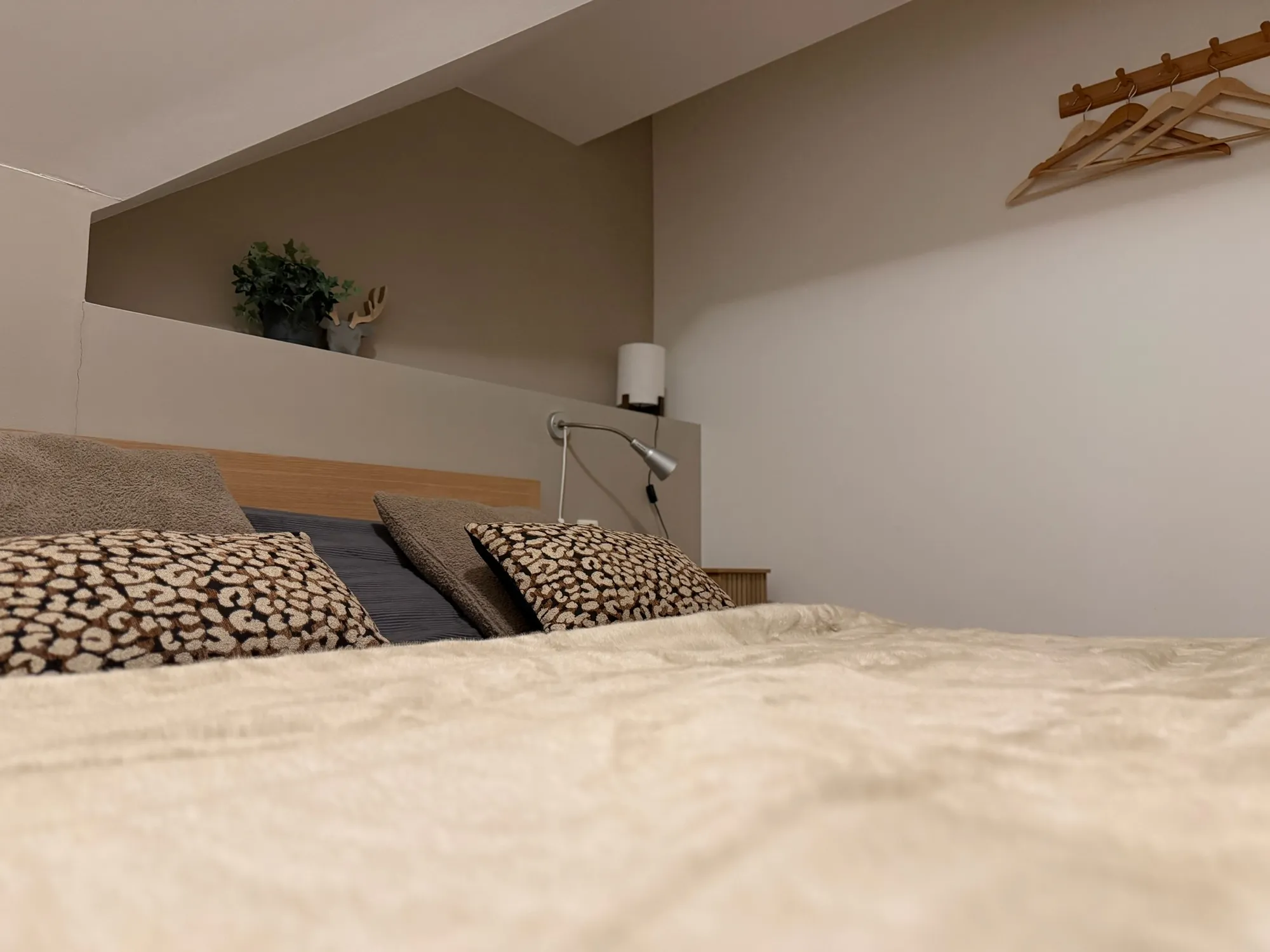 Opgemaakt bed met zachte plaid en kussens in een slaapkamer van Everpine Mountain Lodge
